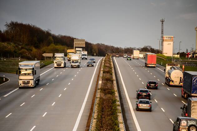 Autos und Lkw fahren auf der A2 bei Helmstedt (Niedersachsen) im Sonnenuntergang.