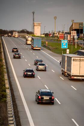 Autos und Lkw fahren auf der A2 bei Helmstedt (Niedersachsen) im Sonnenuntergang.
