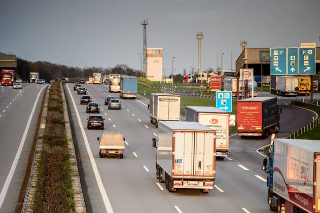 Autos und Lkw fahren auf der A2 bei Helmstedt (Niedersachsen) im Sonnenuntergang.