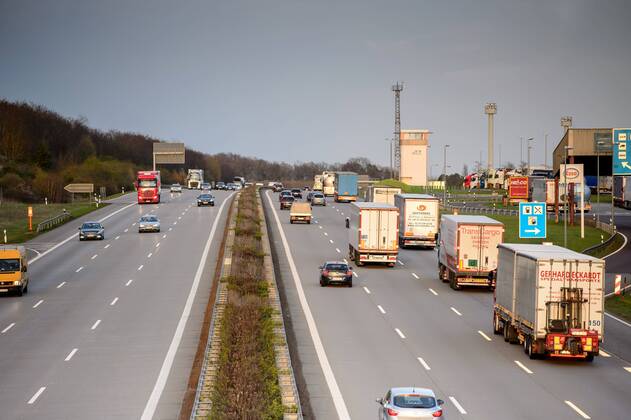 Autos und Lkw fahren auf der A2 bei Helmstedt (Niedersachsen) im Sonnenuntergang.