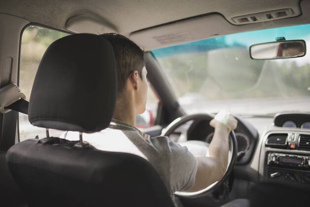 Young man driving car model released Symbolfoto RAEF000253