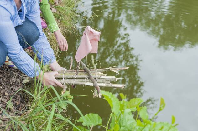 Germany, Woman putting toy raft in water model released Symbolfoto  MJF001567