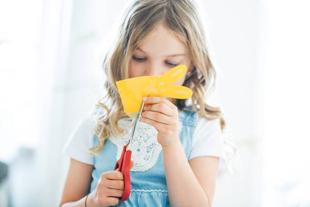 Little girl cutting out paper Easter bunnies model released Symbolfoto property released  WESTF021544