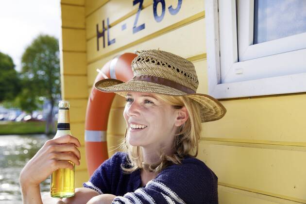 Smiling woman on a house boat with beer bottle model released Symbolfoto property released  FMKF001938