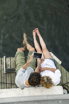 Couple sharing digital tablet at the water model released Symbolfoto property released  FMKF001943