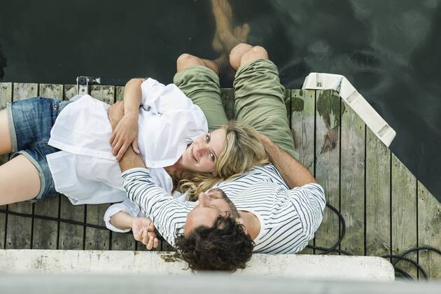 Smiling woman lying on man s lap at the water model released Symbolfoto property released  FMKF001944