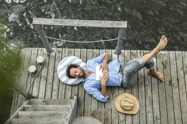 Man lying on platform at the waterside model released Symbolfoto property released  FMKF001970