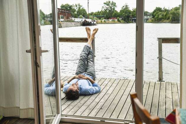 Man lying on wooden deck of a house boat model released Symbolfoto property released  FMKF001973