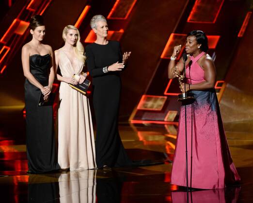 Actress Uzo Aduba (R) accepts the award for Outstanding Supporting Actress in a Drama Series for Orange Is the New Black from actresses Emma Roberts (L) and Jamie Lee Curtis (C) onstage during the 67th Primetime Emmy Awards in the Microsoft Theater in Los Angeles on September 20, 2015.  LAP20150920835 KENxMATSUI