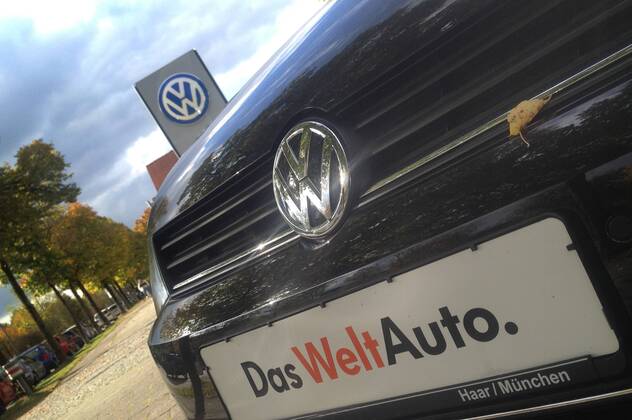 Themenbild VW Volkswagen Abgas Skandal, VW Motorhaube,Kuehlergrill VW Golf mit VW Emblem,Markenemblem,Logo mit Licht reflexionen,Slogan DAS WELT AUTO.
