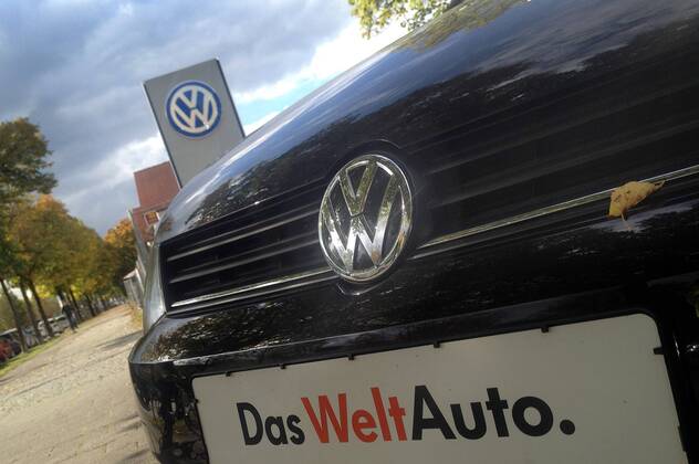 Themenbild VW Volkswagen Abgas Skandal, VW Motorhaube,Kuehlergrill VW Golf mit VW Emblem,Markenemblem,Logo mit Licht reflexionen,Slogan DAS WELT AUTO.