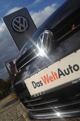 Themenbild VW Volkswagen Abgas Skandal, VW Motorhaube,Kuehlergrill VW Golf mit VW Emblem,Markenemblem,Logo mit Licht reflexionen,Slogan DAS WELT AUTO.