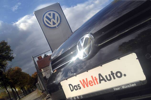 Themenbild VW Volkswagen Abgas Skandal, VW Motorhaube,Kuehlergrill VW Golf mit VW Emblem,Markenemblem,Logo mit Licht reflexionen,Slogan DAS WELT AUTO.
