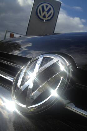 Themenbild VW Volkswagen Abgas Skandal, VW Motorhaube,Kuehlergrill VW Golf mit VW Emblem,Markenemblem,Logo mit Licht reflexionen.