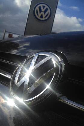 Themenbild VW Volkswagen Abgas Skandal, VW Motorhaube,Kuehlergrill VW Golf mit VW Emblem,Markenemblem,Logo mit Licht reflexionen.