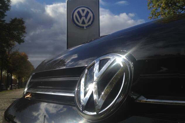 Themenbild VW Volkswagen Abgas Skandal, VW Motorhaube,Kuehlergrill VW Golf mit VW Emblem,Markenemblem,Logo mit Licht reflexionen.