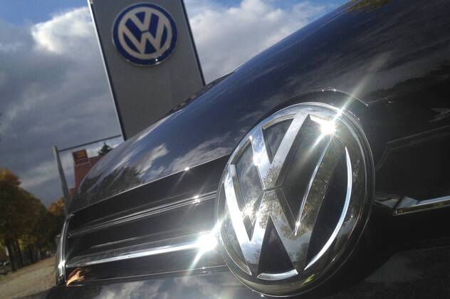 Themenbild VW Volkswagen Abgas Skandal, VW Motorhaube,Kuehlergrill VW Golf mit VW Emblem,Markenemblem,Logo mit Licht reflexionen.