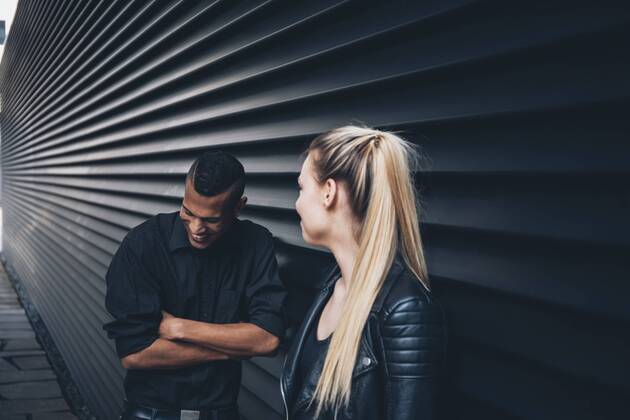 Black dressed young couple standing in front of black facade model released Symbolfoto CHAF001373