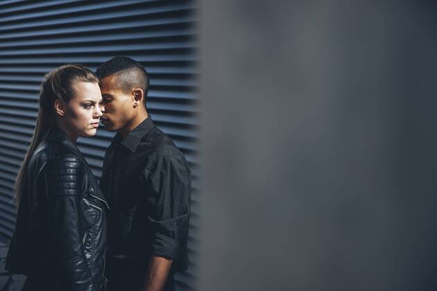 Black dressed young couple standing in front of black facade model released Symbolfoto CHAF001383