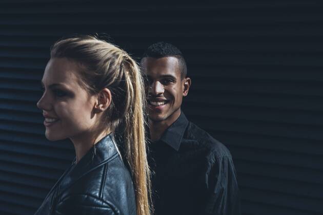 Black dressed young couple standing in front of black facade model released Symbolfoto CHAF001386