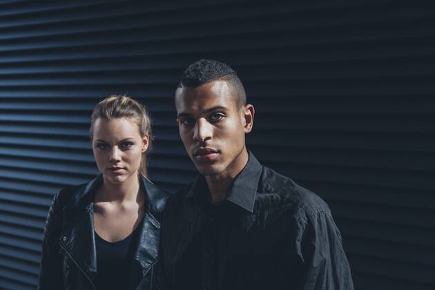Black dressed young couple standing in front of black facade model released Symbolfoto CHAF001387