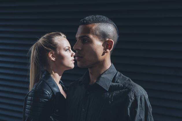Black dressed young couple standing in front of black facade model released Symbolfoto CHAF001388