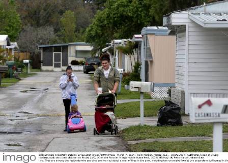 March 7, 2014 - Palm Harbor, Florida, U.S. - DOUGLAS R. CLIFFORD.A pair of young mothers walk with their children on Friday (3 7 14) in the Frontier Village Mobile Home Park, 30700 US Hwy 19, Palm Harbor, where they live. They are among the residents who say they are worried about a rash of fires in the park, including two overnight fires at two separate mobil homes in the park. - ZUMAs70