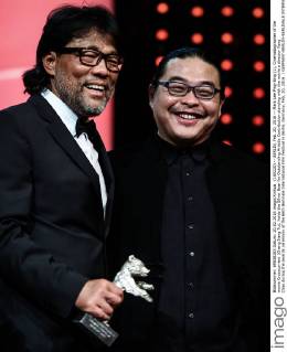 (160220) -- BERLIN, Feb. 20, 2016 -- Mark Lee Ping-Bing (L), Cinematographer of the movie Crosscurrent (Chang Jiang Tu), holds the Silver Bear for Outstanding Artistic Contribution standing with the movie s director Yang Chao during the awards ceremony of the 66th Berlinale International Film Festival in Berlin, Germany, Feb. 20, 2016. ) GERMANY-BERLIN-BERLINALE INTERNATIONAL FILM FESTIVAL-AWARDS CEREMONY-MARK LEE ZhangxFan 