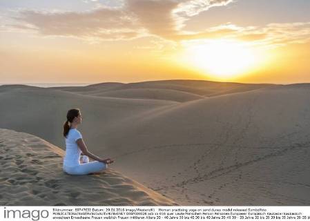 Woman practising yoga on sand dunes model released Symbolfoto DIGF000026