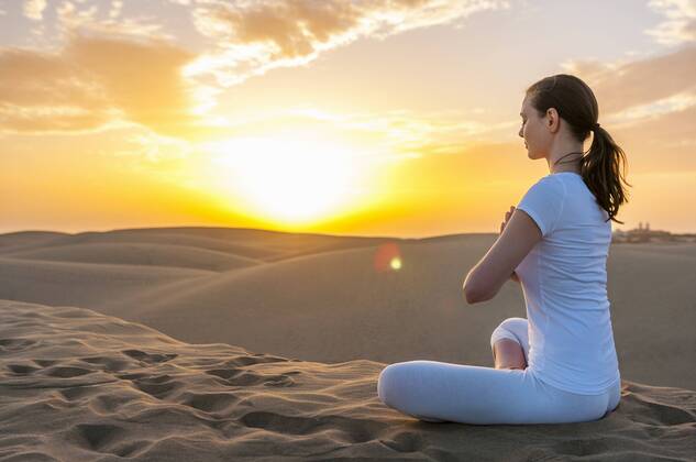 Woman practising yoga on sand dunes model released Symbolfoto DIGF000028