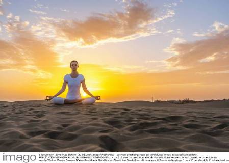 Woman practising yoga on sand dunes model released Symbolfoto DIGF000030