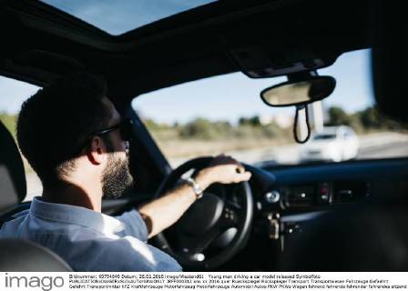 Young man driving a car model released Symbolfoto JRFF000312