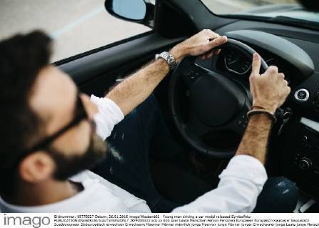 Young man driving a car model released Symbolfoto JRFF000323