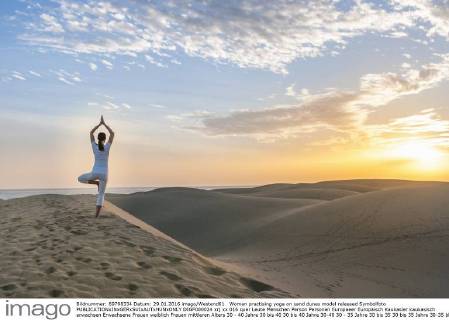 Woman practising yoga on sand dunes model released Symbolfoto DIGF000024