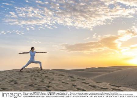 Woman practising yoga on sand dunes model released Symbolfoto DIGF000025