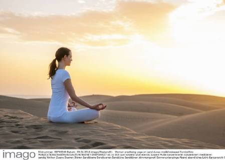 Woman practising yoga on sand dunes model released Symbolfoto DIGF000027