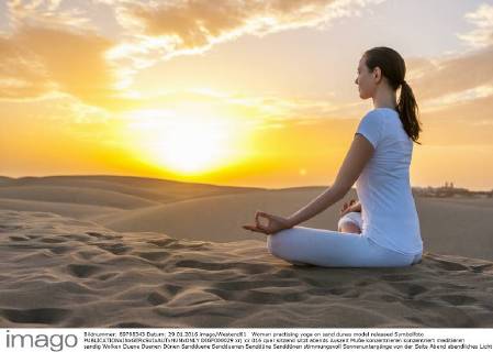 Woman practising yoga on sand dunes model released Symbolfoto DIGF000029