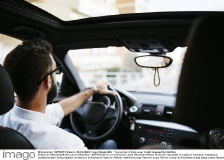Young man driving a car model released Symbolfoto JRFF000316