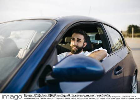 Young man driving a car model released Symbolfoto JRFF000318