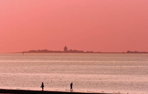 Paar bei Flut im Watt vor der Hamburger Insel Neuwerk im Abendlicht, Deutschland, Hamburgisches Wattenmeer-Nationalpark two person in the wadden sea in front of the Wadden Sea in the evening, Germany, Hamburgisches Wattenmeer National Park BLWS422757 Copyright: xblickwinkel G.xFranzx