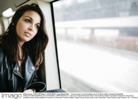 Young woman on train looking out of window model released Symbolfoto JRFF000629