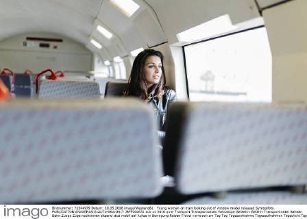 Young woman on train looking out of window model released Symbolfoto JRFF000631