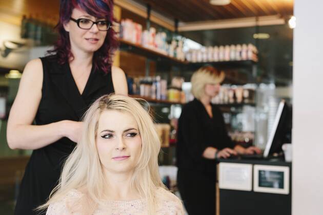 A hair stylist and a client, a young woman with long blonde hair, at a hair salon. A hair stylist and a client, a young woman with long blonde hair, at a hair salon. 21691