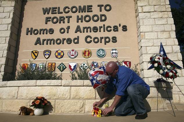 FOR METRO - U.S. Army Spc. Ryan Hill lays flowers near the main entrance to Fort Hood Army Post Saturday Nov. 7, 2009 in Fort Hood, Tx. PHOTO BY EDWARD A. ORNELAS eaornelas@express-news.net) - ZUMAa27_