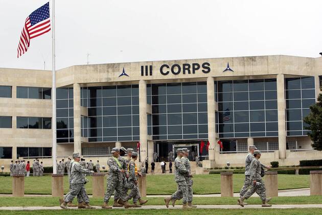 FOR METRO - U.S. Army soldiers pass III Corps headquarters where an American flag flies at half staff on Fort Hood Army Post Monday Nov. 9, 2009 in Fort Hood, Tx. PHOTO BY EDWARD A. ORNELAS eaornelas@express-news.net) - ZUMAa27_