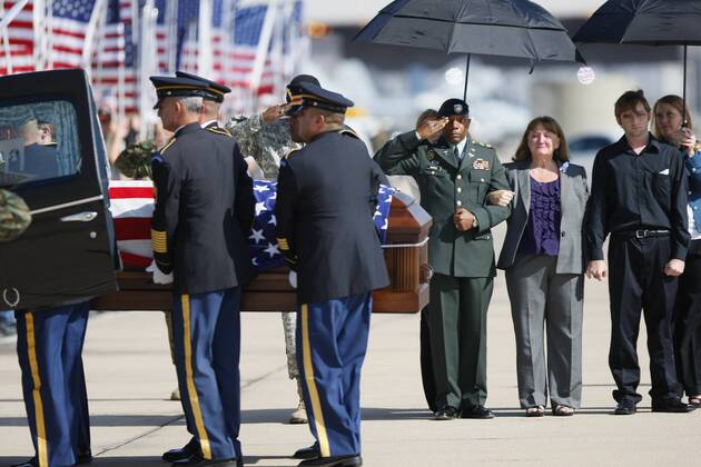 November 13, 2009_San Diego_California_USA_(LtoR) California Army National Guard Casuelity Assistance Officer Maj. Timothy Grimes and Christine Gaffaney, widow Army Capt. John Gaffaney and Matthew Gaffaney son of Army Capt. John Gaffaney of Serra Mesa who was killed at Fort Hood watch his casket being loaded into a hearse. Capt. Gaffaney was flown to MCAS Miramar to be handed over to his family._Mandatory Photo - ZUMAs44_