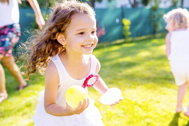 Little girl having fun with water bombs in the garden model released Symbolfoto  HAPF000765