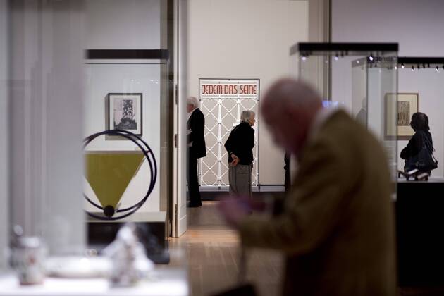 The British View Germany - Memories of a Nation, Exhibition Gropius-Bau DEU, Deutschland, Germany, Berlin, 07.10.2016 Besucher betrachtet das Lagertor des Konzentrationslager KZ Buchenwald mit der Inschrift Jedem das Seine in der Ausstellung Der Britische Blick Deutschland - Erinnerungen einer Nation, The British View German - Memories of a Nation, im Martin-Gropius-Bau in Berlin. Die Ausstellung eroeffnet am 08. Oktober und geht bis 09. Januar und praesentiert ca 200 Objekte welche einen Bezug zu den letzten 600 Jahre Geschichte in Deutschland haben. Sie zeigt Spuren deutscher Identitaet aus britischer Perspektive. Visitor next to a gate from the former Buchenwald concentration camp with the words Jedem das Seine, To Each What He Deserves, on display during his exhibition Der Britische Blick Deutschland - Erinnerungen einer Nation, The British View German - Memories of a Nation, at the