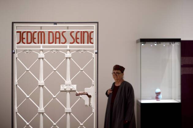 The British View Germany - Memories of a Nation, Exhibition Gropius-Bau DEU, Deutschland, Germany, Berlin, 07.10.2016 Besucher betrachtet das Lagertor des Konzentrationslager KZ Buchenwald mit der Inschrift Jedem das Seine in der Ausstellung Der Britische Blick Deutschland - Erinnerungen einer Nation, The British View German - Memories of a Nation, im Martin-Gropius-Bau in Berlin. Die Ausstellung eroeffnet am 08. Oktober und geht bis 09. Januar und praesentiert ca 200 Objekte welche einen Bezug zu den letzten 600 Jahre Geschichte in Deutschland haben. Sie zeigt Spuren deutscher Identitaet aus britischer Perspektive. Visitor next to a gate from the former Buchenwald concentration camp with the words Jedem das Seine, To Each What He Deserves, on display during his exhibition Der Britische Blick Deutschland - Erinnerungen einer Nation, The British View German - Memories of a Nation, at the