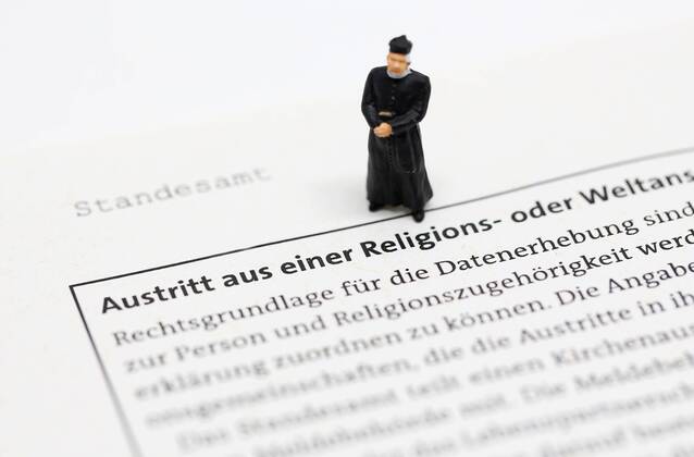Nuernberg Symbolfoto, Themenbild Kirchenaustritt, Kirchensteuer. Geistlicher mit Soutane steht auf Formular fuer Kirchenaustritt. Copyright: xWuestx Eibner-Pressefotox EP_fwt
